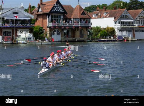 River Thames Scene Of Rowing Eight And Waterside Houses During The