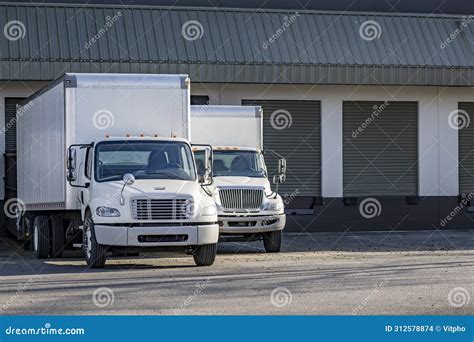 Day Cab White Middle Duty Rigs Semi Trucks With Long Box Trailers Standing In Warehouse Dock