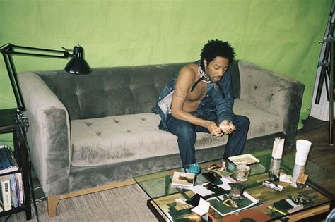 A Man Sitting On Top Of A Couch Next To A Table