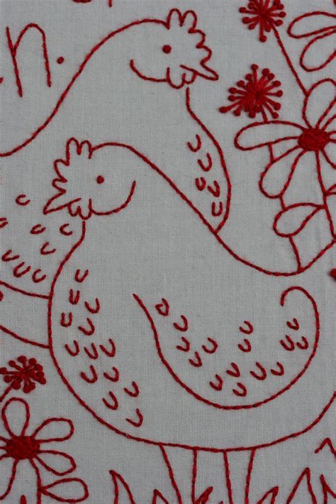 A Red And White Embroidered Chicken On A White Background With Flowers