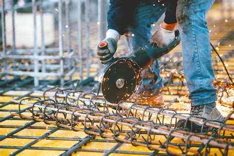 Premium Photo | Worker using an angle grinder for cutting steel making ...