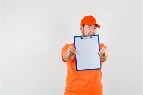 Free Photo Delivery Man Showing Clipboard In Orange T Shirt Cap And