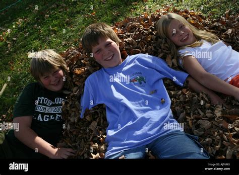 kids playing with leaves in autumn Stock Photo - Alamy