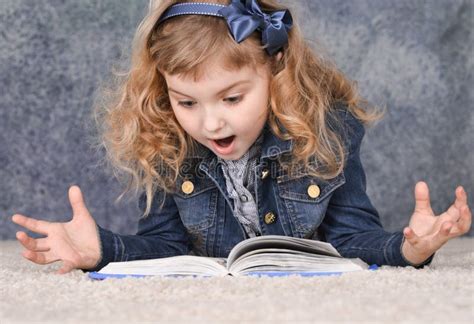 Cute Little Girl Reading Book while Lying on Floor Stock Image - Image ...