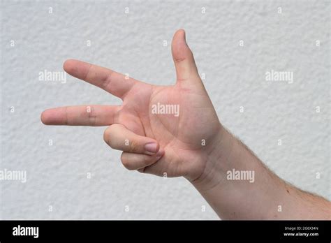 Man Holding Up Three Finger On His Hand Over White In A Counting Or