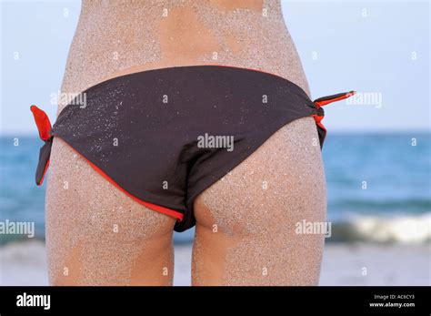 Beautiful Sandy Beach Butt Bum In Chocolate Orange Swimsuit Of A Young Caucasian Slim Healthy