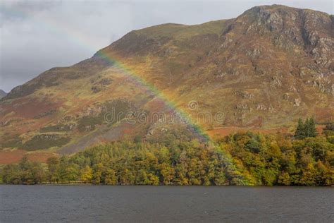 An Autumn Day Around Buttermere Lake As A Rainbow Appears In The Lake