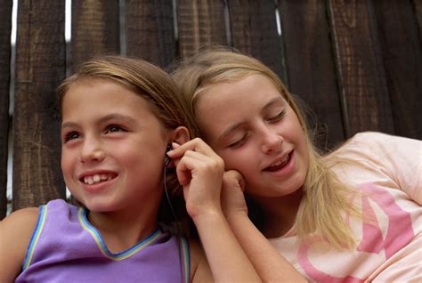 Two Girls Sharing Earphones Outdoors Free Photo Download Freeimages