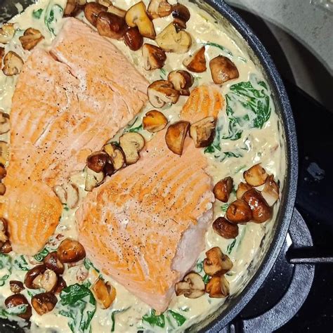 Two Salmons And Mushrooms Cooking In A Skillet