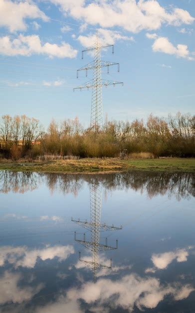 Premium Photo Reflection Of Electricity Pylon On Lake Against Sky