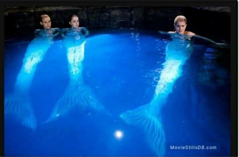 Three People Are Swimming In The Water With Their Backs Turned To Look