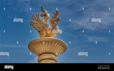 Golden figurine of zilant over blue sky background. Snake with wings, a ...