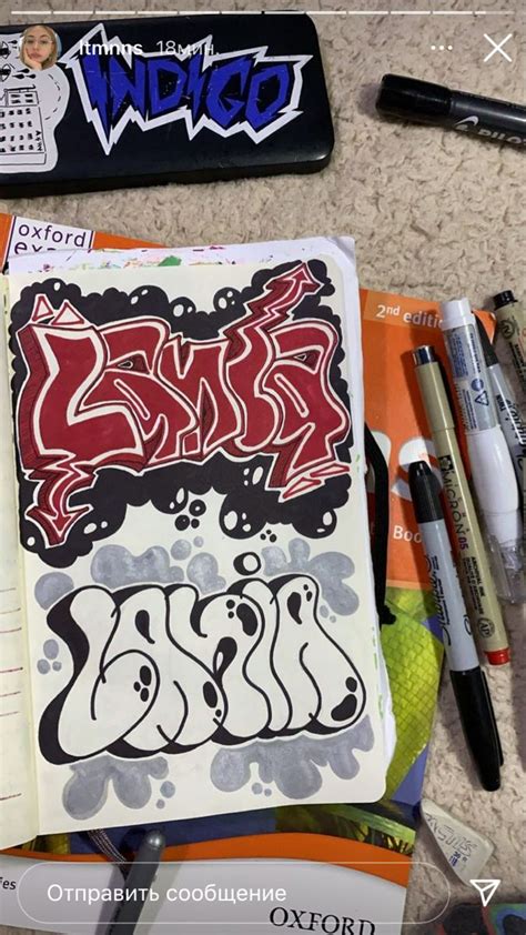 An Open Notebook With Graffiti On It Sitting Next To Pens And Other