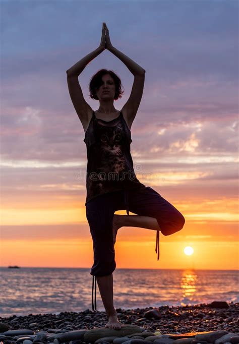 Silhouette De Mujer Practicando Yoga Al Atardecer Foto De Archivo