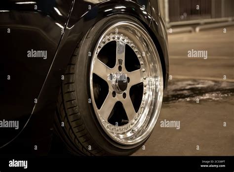 Alloy polished rims of a sports car. Wide wheels with stretched tires ...