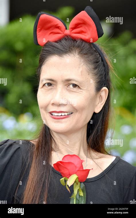 Old Filipina Female Senior Smiling With A Flower Stock Photo Alamy