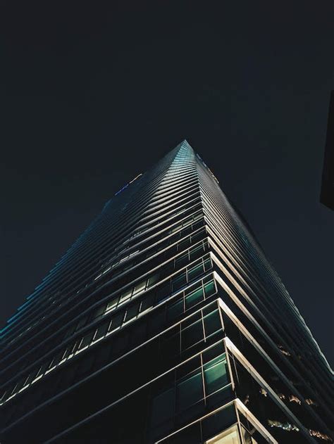 Low Angle View Of A Modern Skyscraper At Night · Free Stock Photo