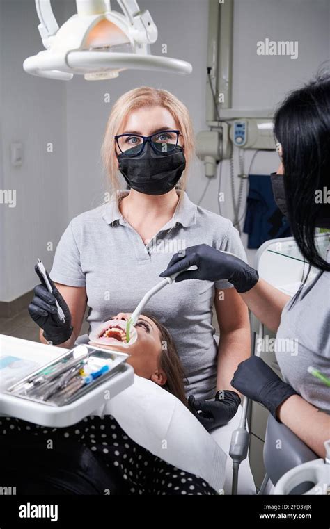 Female Dentist And Her Assistant Working Together Dental Tools In