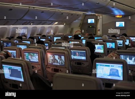 Plane cabin interior, passengers watching movies Stock Photo - Alamy