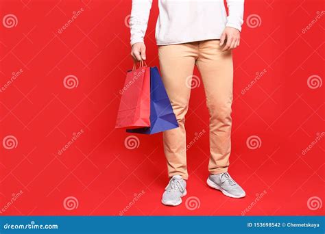 Hombre Joven Con Las Bolsas De Papel En Fondo Rojo Espacio Para El