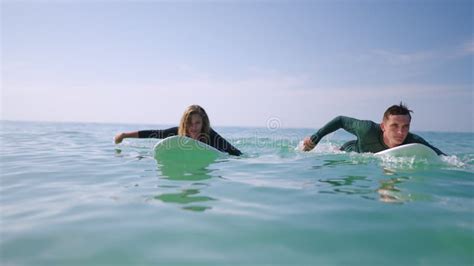 Surfers In Swimwear Paddling On Surfboards Man Woman In Swimsuit Swim