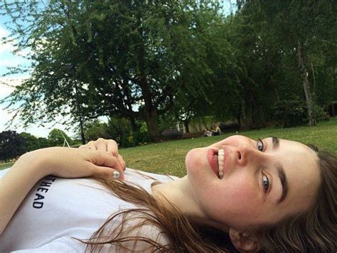 A Woman Laying On Top Of A Lush Green Field