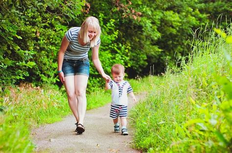 Mãe e filho estão brincando no parque e rindo em uma caminhada de verão