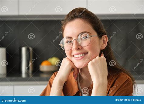 Close Up Portrait Of Young Woman In Her 20s Sitting In Kitchen