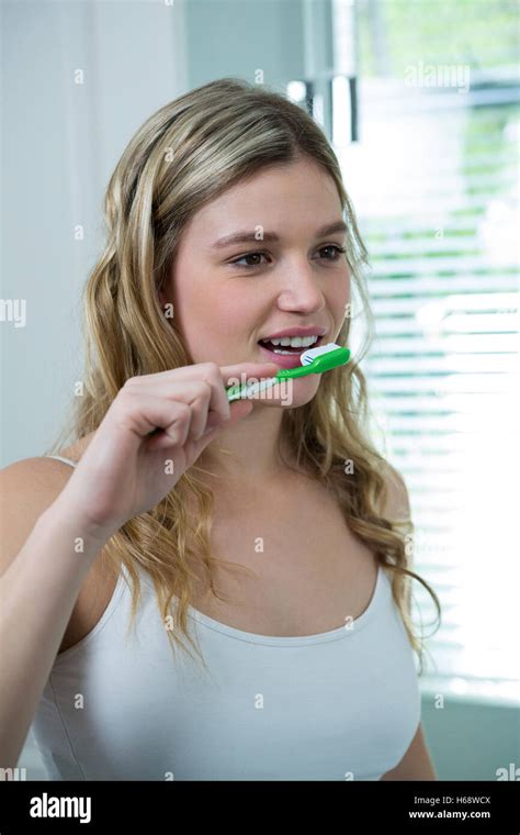 Woman Brushing Her Teeth In Bathroom Stock Photo Alamy