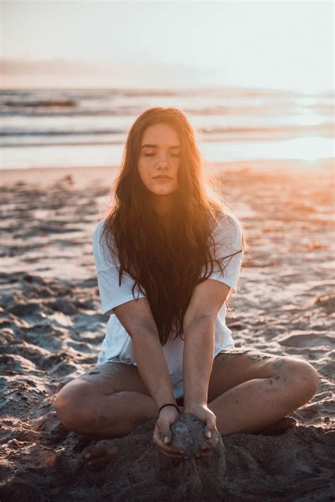 Beautiful woman on the beach at dawn wearing denim shorts on Beautiful Women Featured