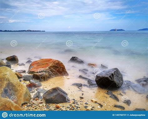 Las Ondas Y Las Rocas Lisas Sedosas Hermosas De Agua En La Orilla De