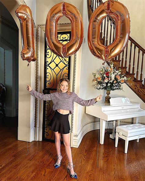 A Woman Standing In Front Of Balloons That Spell Out The Word 50 And An