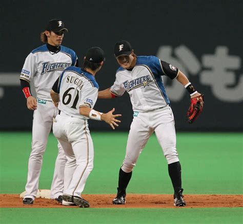 試合に勝利し喜ぶ、日本ハムの杉谷拳士内野手（中）と糸井嘉男外野手（右）。左は陽岱鋼（ヨウ・ダイカン）外野手（2012年撮影） ― スポニチ