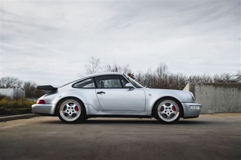 A Silver Porsche Parked In A Parking Lot