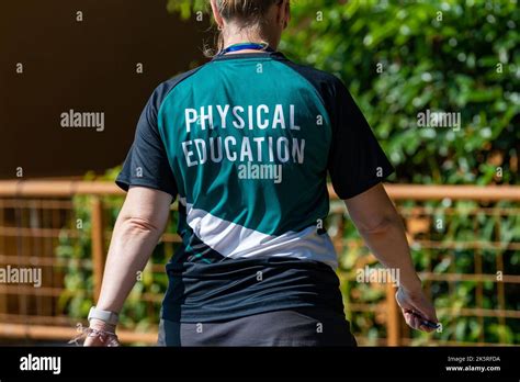 Back View Of Swimming Coaches Wearing Coach Shirt Working At An