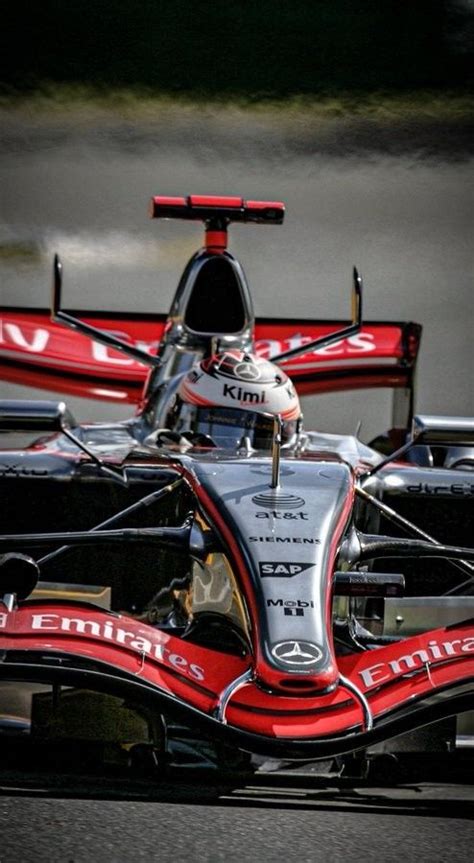 A Red And Black Race Car Driving On A Track