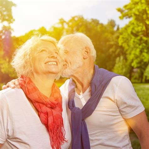 Old Man Kissing Senior Woman On Cheek Stock Image Image Of Green