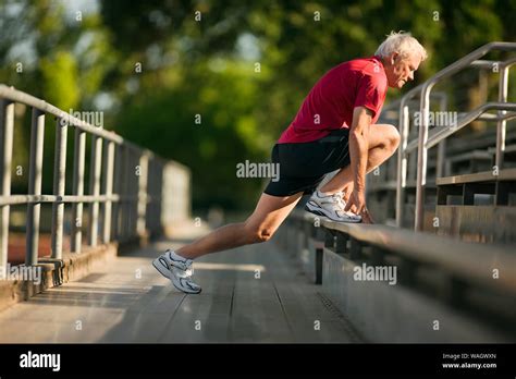 Mature Man Warming Up With Stretches On Bleachers Stock Photo Alamy