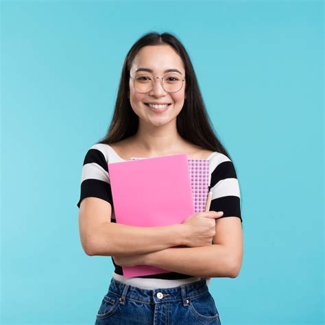 Mujer Sonriente Que Sostiene La Pila De Libros Foto Gratis