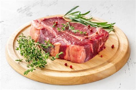 Premium Photo Raw Rib Eye Beef Steak With Thyme And Rosemary