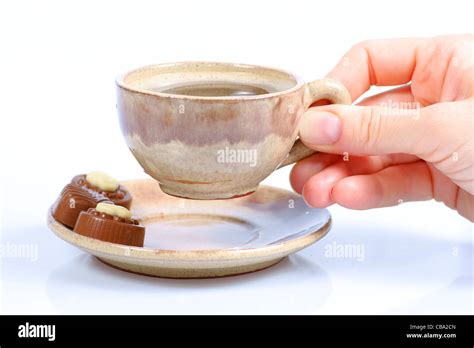 Chocolate Pralines Cup With Black Coffee And Female Hand On White