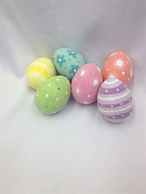 Six Decorated Easter Eggs Sitting On Top Of A White Surface With Polka