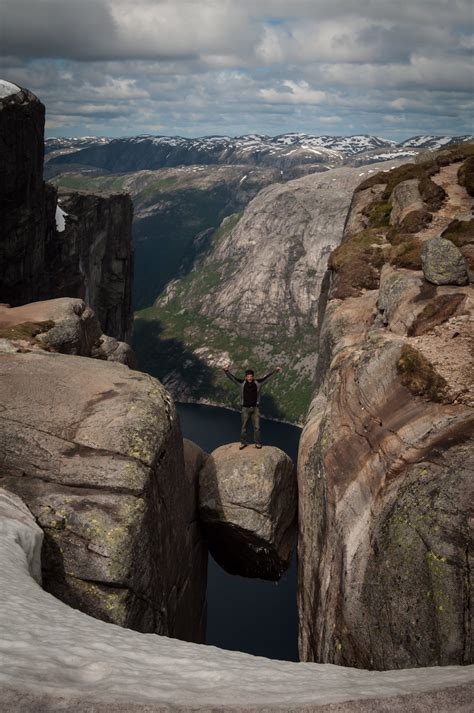 Stand on a Boulder Wedged Between Mountains at Kjeragbolten in Norway ...