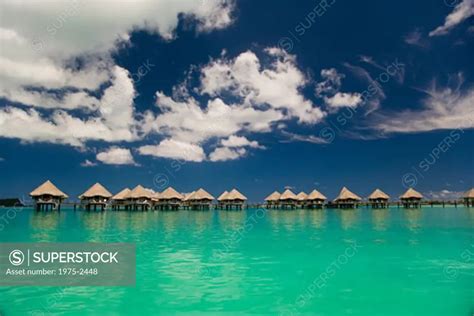 Reflection of resort beach huts in the sea, Bora Bora, Tahiti, French ...