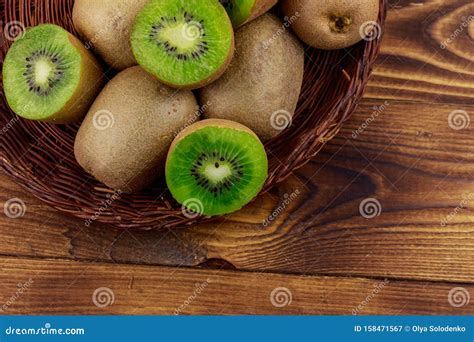 Kiwi Fruits In Wicker Basket On Wooden Table Top View Stock Image