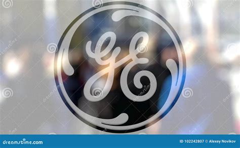 General Electric Logo On A Glass Against Blurred Crowd On The Steet