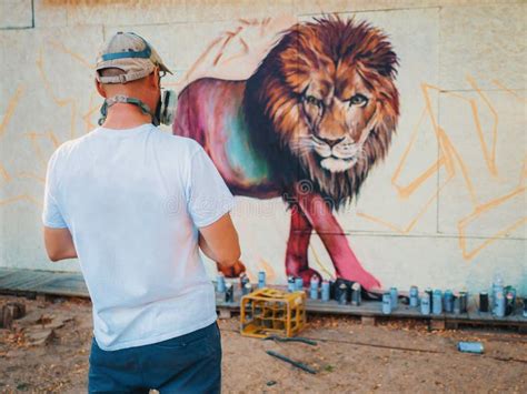 Graffiti Artist Painting on Street Wall. Man with Aerosol Spray Bottle ...