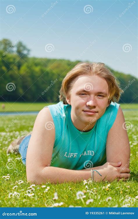 Menino Do Adolescente Que Encontra Se Na Grama Imagem De Stock Imagem