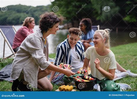 Group Of Multiracial Young Friends Camping In Campsite Near Lake And