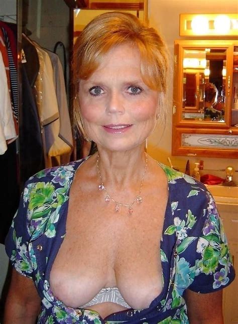 Une Femme Mature Souriante Se Retrouve Dans La Salle De Bain Et Elle Y